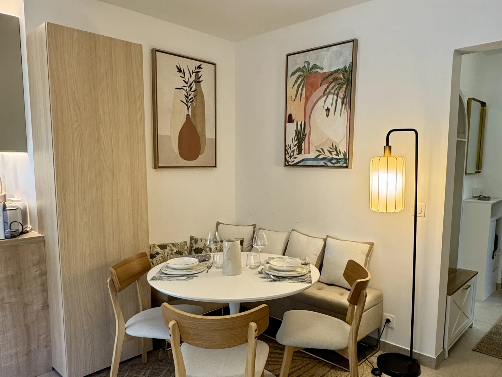 Coin repas d'un studio rénové à Nice Cimiez, table ronde et banquette sur mesure, photo prise après livraison