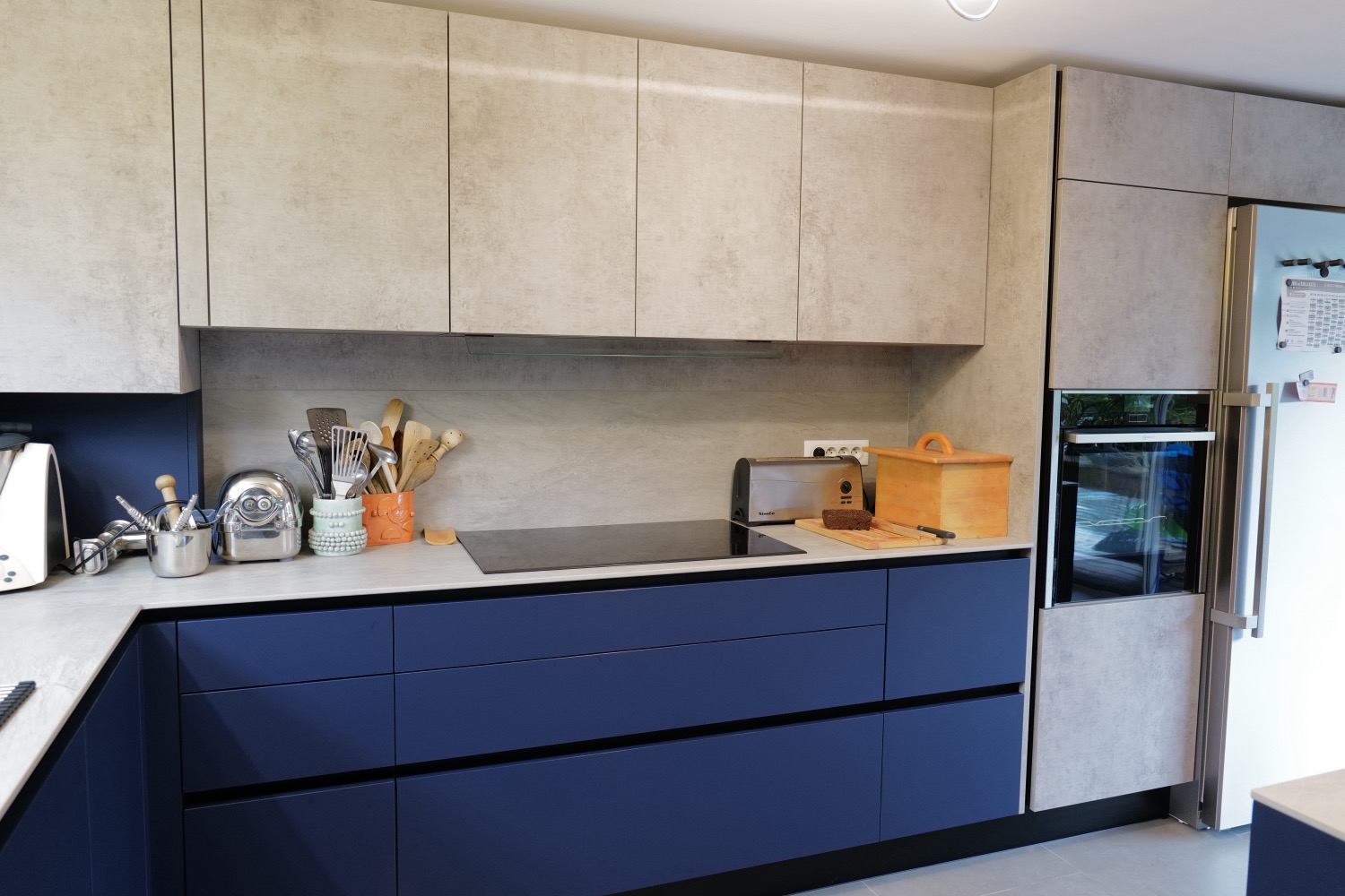 Cuisine contemporaine Roquefort – meubles Fenix bleu et finition béton ciré