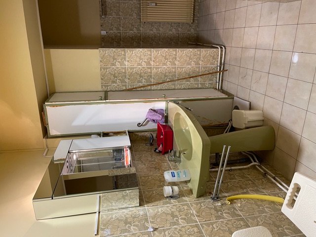 Vue d’un lavabo ancien avec aménagement limité nécessitant modernisation